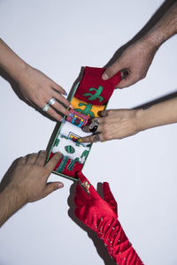 cactus figured socks in a box. there are six socks, two of them in red colour, two socks in white colour, one in pink colour, one in yellow colour