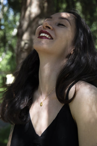 happy woman wearing eye and eyelashes encrypted necklace