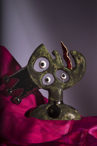 King Lear Bust with and shiny glazed crown. Its eyes look opposite sides. on a red scarf