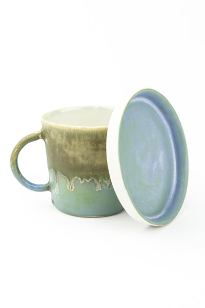 green and turquoise coloured cup with its plate