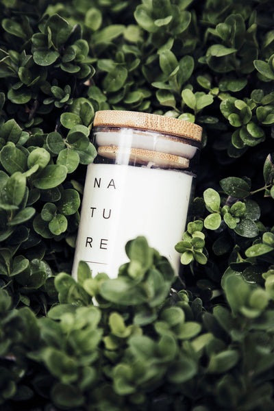 candle in glass jar with wooden lid in greens