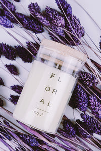 candle in glass jar with wooden lid on lavender background